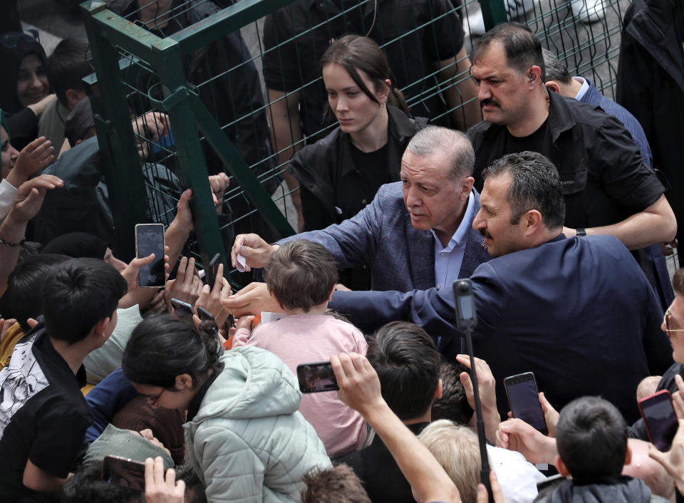 Turkey's President Recep Tayyip Erdogan with supporters at a polling station, in Istanbul, Turkey, Sunday, May 14, 2023. Election polls have closed Sunday in Turkey, where President Erdogan's leadership hung in the balance after a strong challenge from an opposition candidate. (DHA via AP)