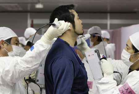 A worker is screened for radiation as he enters the emergency operation center at Tokyo Electric Power Co. (TEPCO)'s tsunami-crippled Fukushima Daiichi nuclear power plant in Fukushima prefecture in this February 20, 2012 file photo. REUTERS/Issei Kato/Files