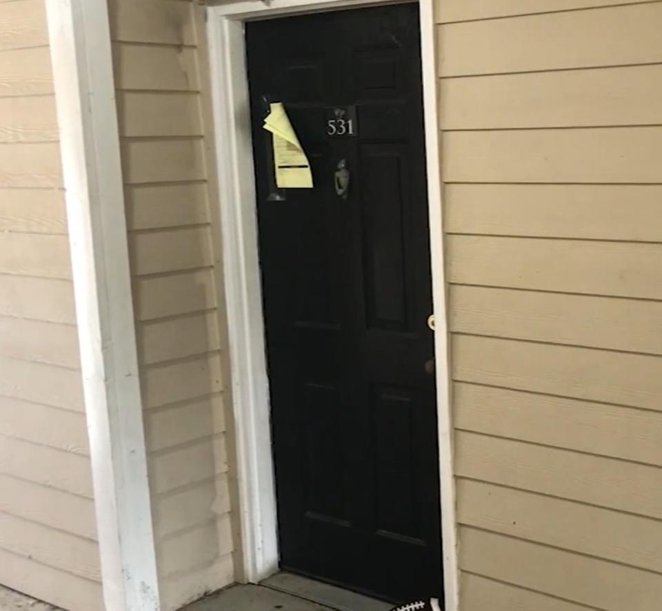 La puerta del apartamento en Houston, Texas, donde se halló el cadáver ya descompuesto de un niño y donde otros tres menores vivían abandonados. (Captura de video / ABC13)