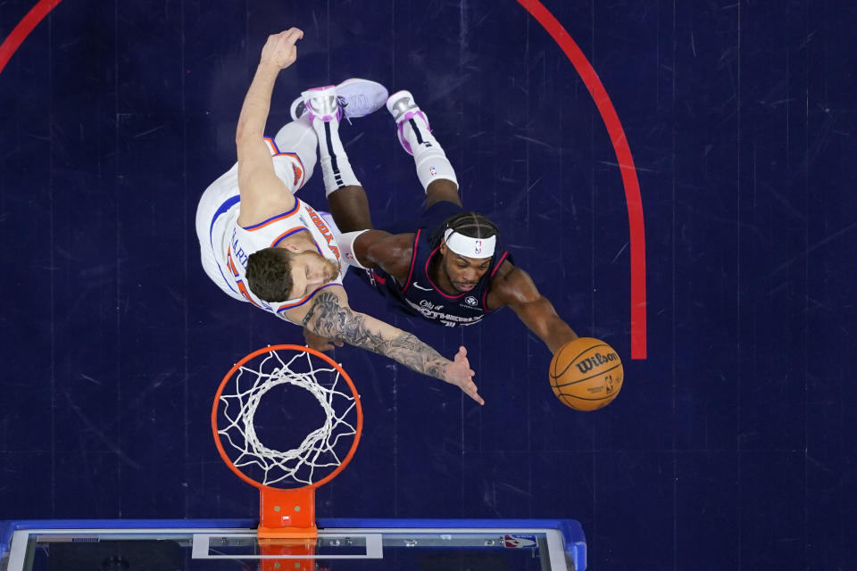 Philadelphia 76ers' Buddy Hield, right, goes up for a shot against New York Knicks' Isaiah Hartenstein during the first half of an NBA basketball game, Thursday, Feb. 22, 2024, in Philadelphia. (AP Photo/Matt Slocum)