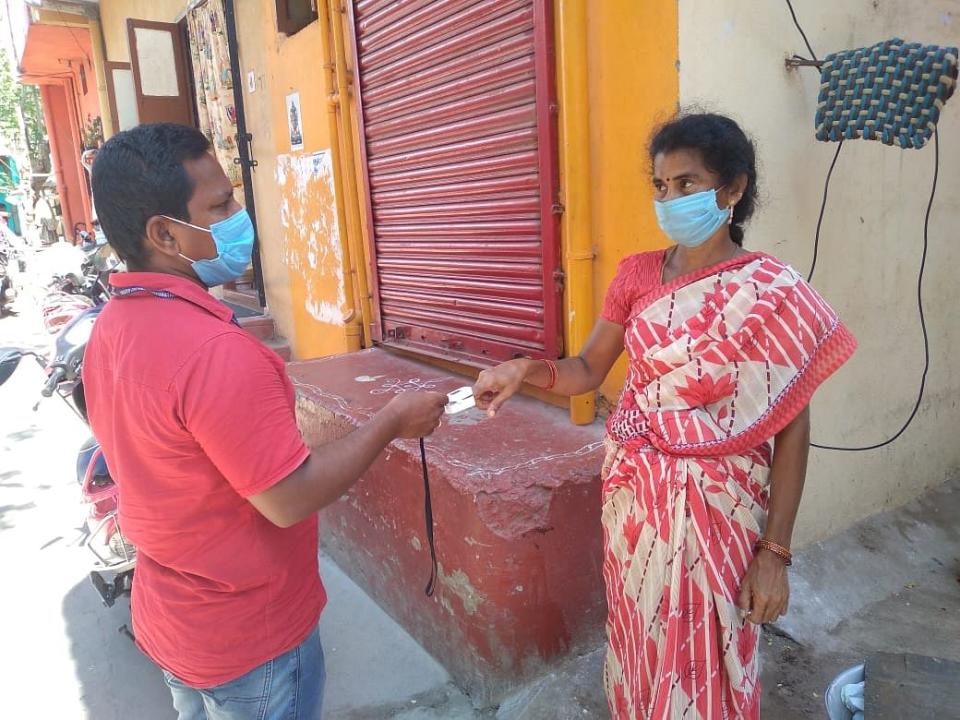 A health volunteer takes oxygen saturation reading.