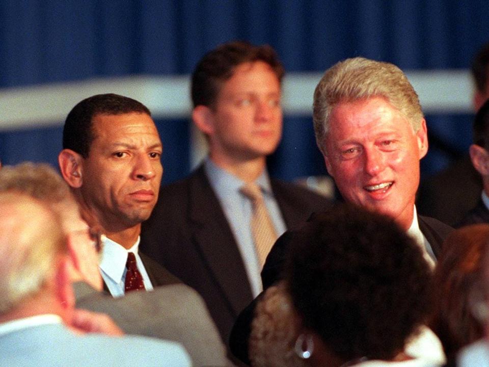 WASHINGTON, DC - JULY 28: Secret Service Agent Larry Cockell (L) watches US President Bill Clinton meet with supporters after the National Council of Senior Citizens Conference Dinner in Washington 28 July. It was Cockell's first day back after testifying before the grand jury investigating the Monica Lewinsky affair. (Photo credit should read WILLIAM PHILPOTT/AFP via Getty Images)