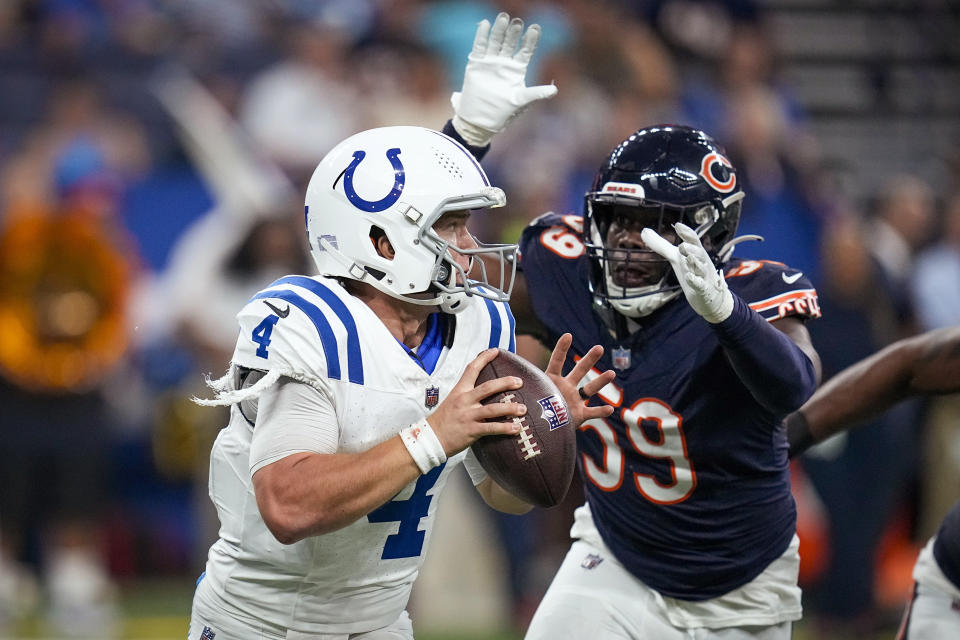 Indianapolis Colts quarterback Sam Ehlinger (4) runs from Chicago Bears linebacker Jalen Harris (59) during the second half of an NFL preseason football game in Indianapolis, Saturday, Aug. 19, 2023. (AP Photo/Darron Cummings)