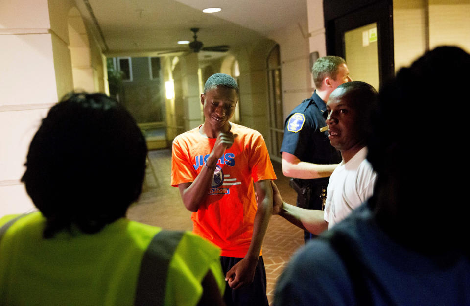 A distraught man is comforted as a group of concerned people arrive inquiring about the shooting. (AP Photo/David Goldman)