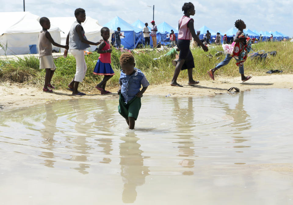 A child plays in a puddle at a camp for displaced survivors of cyclone Idai in Beira, Mozambique,Tuesday, April, 2, 2019. Mozambican and international health workers raced Monday to contain a cholera outbreak in the cyclone-hit city of Beira and surrounding areas, where the number of cases has jumped to more than 1,000. (AP Photo/Tsvangirayi Mukwazhi)