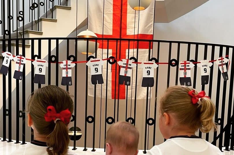 Three kids with back to camera in daddy england shirts