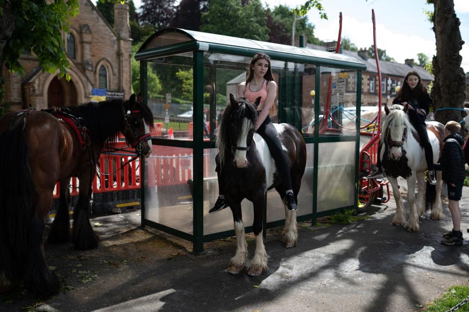 Girls wait on their horses on the first day of the annual Appleby Horse Fair, in the town of Appleby-in-Westmorland, north west England on June 9, 2022.