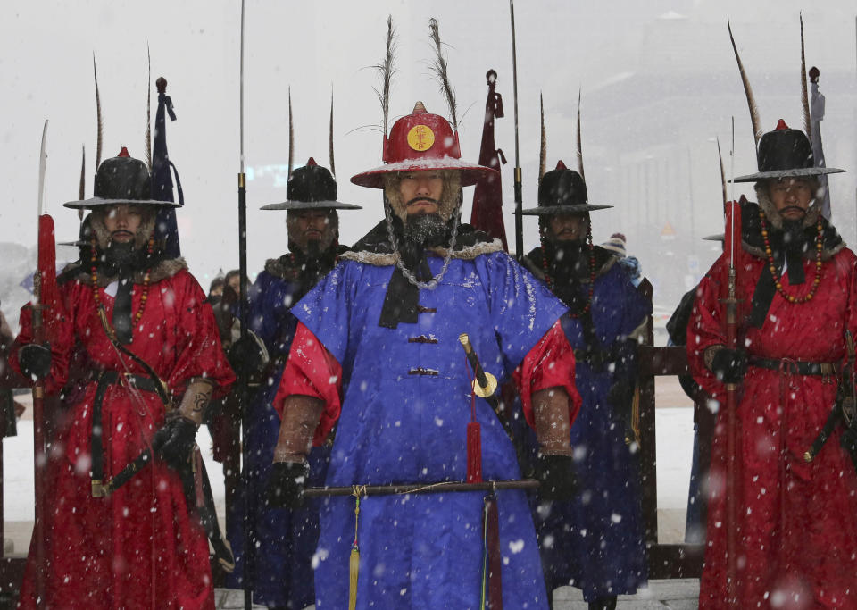 Palace guards wearing traditional military uniforms stand during snowfall at the landmark Gyeongbok Palace, the main royal palace during the Joseon Dynasty, in Seoul, South Korea, Thursday, Dec. 13, 2018. (AP Photo/Ahn Young-joon)