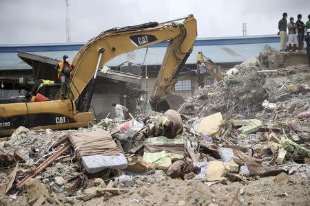 Beds used by guests are seen near an excavator at the site of the collapsed Synagogue Church of All Nations in the Ikotun-Egbe neighbourhood of Nigeria's commercial capital Lagos, September 17, 2014. REUTERS/Akintunde Akinleye