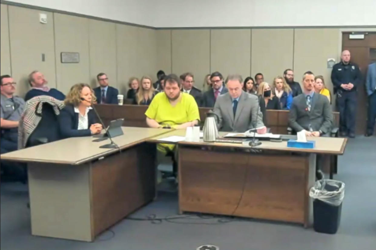 In this image taken from El Paso County District Court video, Anderson Lee Aldrich, 22, center, sits during a court appearance in Colorado Springs, Colo., Tuesday, Dec. Nov. 6, 2022. (via AP)