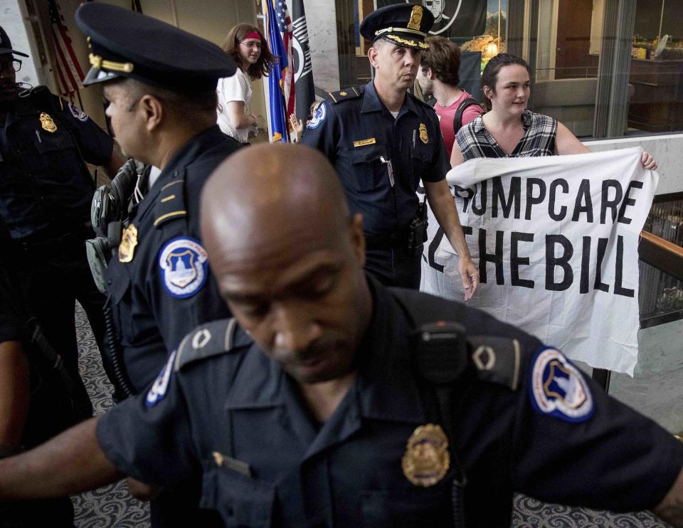 <p>Polizeibeamte im US-amerikanischen Washington bereiten sich darauf vor, eine Gruppe Demonstranten festzunehmen, die außerhalb des Büros des Senators Dean Heller in Capitol Hill gegen die Gesundheitsreform der Trump-Administration protestieren. (AP Photo/Andrew Harnik) </p>