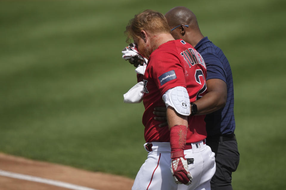 Boston Red Sox Justin Turner is walked off the field after being hit in the face on a pitch by Detroit Tigers starting pitcher Matt Manning in the first inning of their spring training baseball game in Fort Myers, Fla., Monday, March 6, 2023. (AP Photo/Gerald Herbert)