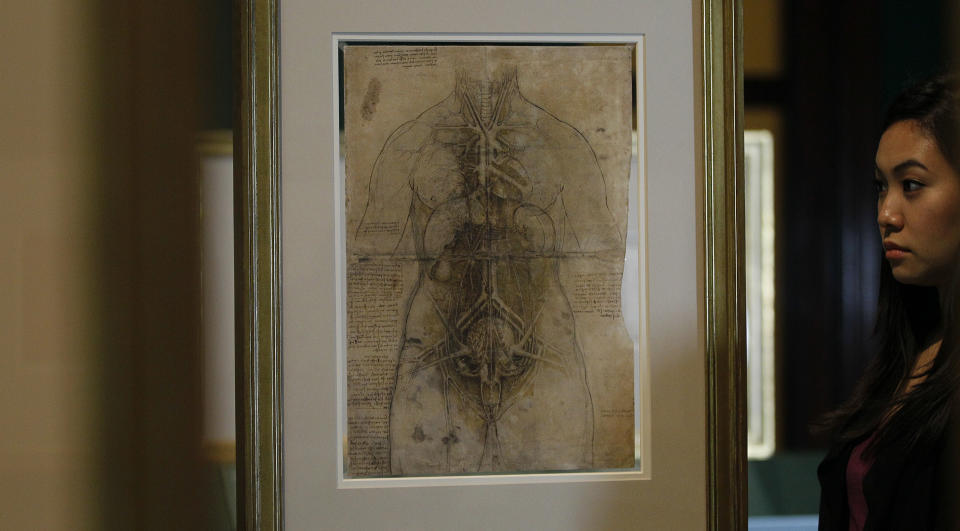 An employee of the Queen's Gallery, Hanae Tsuji, looks at an ink drawing by Leonardo da Vinci entitled 'The Principal Organs and Vessels of a Woman', around1508-10, at an exhibition of his anatomical drawings exhibition at the The Queen's Gallery, London, Monday, April 30, 2012. The display, the largest ever of da Vinci's anatomical works, is open to the public May 4 to Oct. 7. (AP Photo/Alastair Grant)