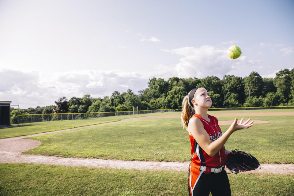 A girl throwing a ball in the air