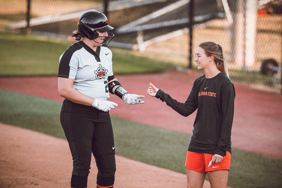 Oklahoma State hitting coach Vanessa Shippy-Fletcher, right, was a volunteer assistant during the playing career of current Cowgirl pitching coach Carrie Eberle, left. Now the two are working together, playing a key role in OSU's postseason success.