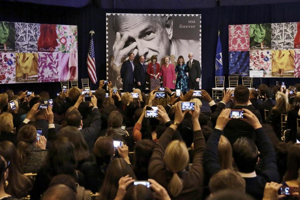 Oscar de la Renta CEO Alexander Bolen, from left, Michael Bloomberg, Vogue Editor Anna Wintour, Hillary Clinton, U.S. Postal Service Vice President Janice Walker and journalist Anderson Cooper pose for photos at an unveiling of commemorative stamps honoring the late designer Oscar de la Renta in Grand Central Terminal, in New York, Thursday, Feb. 16, 2017. (AP Photo/Richard Drew)