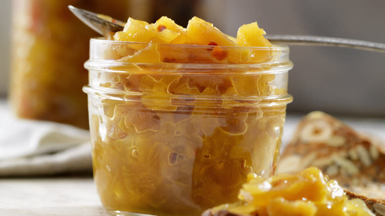 Yellow chutney in open glass jar