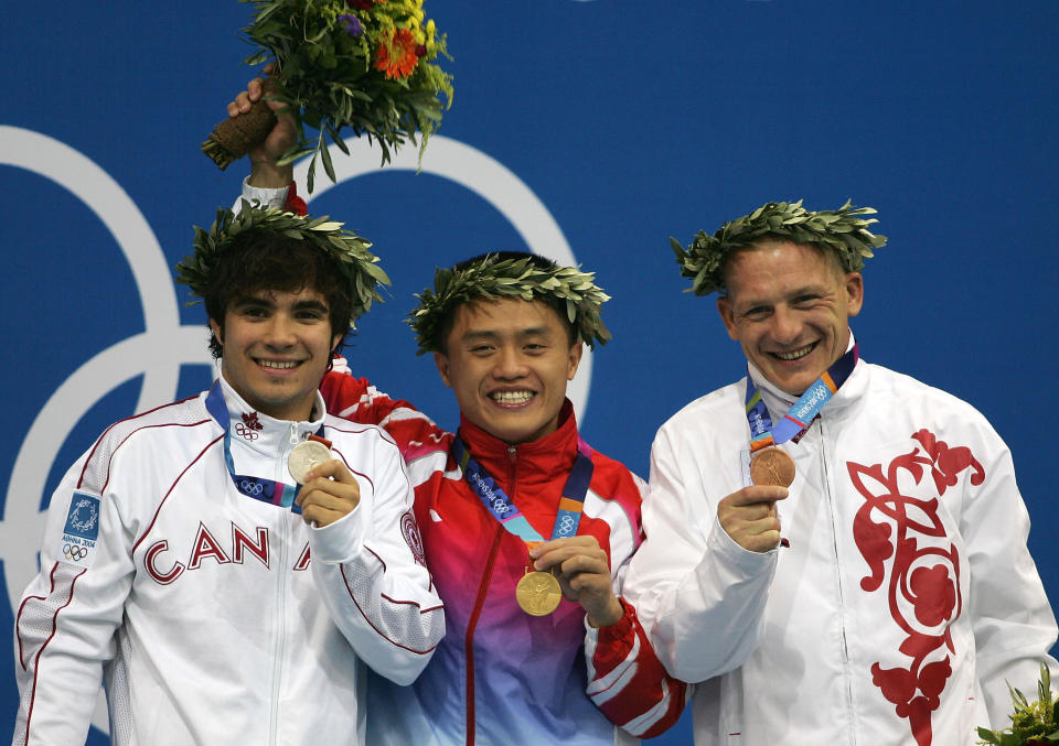 ATHENS - AUGUST 24: (L-R) Alexandre Despatie of Canada (Silver), Bo Peng of China (Gold) and Dmitri Sautin of Russia (Bronze) show their medals at the men's diving 3 metre springboard medal ceremony on August 24, 2004 during the Athens 2004 Summer Olympic Games at the Aquatic Centre Indoor Pool at the Olympic Sports Complex in Athens, Greece. (Photo by Daniel Berehulak/Getty Images for FINA)