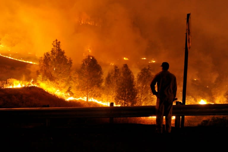 A firefighter watches as flames approach Highway 20 during the Rocky fire near Clear Lake, California on August 2, 2015