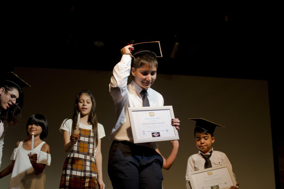 En esta imagen, tomada el 18 de diciembre de 2018, Sebastián (centro), un estudiante transgénero, muestra su diploma en la ceremonia de graduación de la escuela Amaranta Gómez, en Santiago, Chile. Las clases empezaron en abril de 2018 en un espacio prestado en un centro comunitario en la capital chilena. (AP Foto/Esteban Félix)