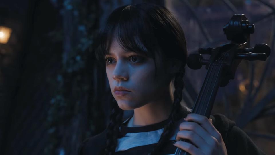 Jenna Ortega as Wednesday playing the cello in Wednesday.