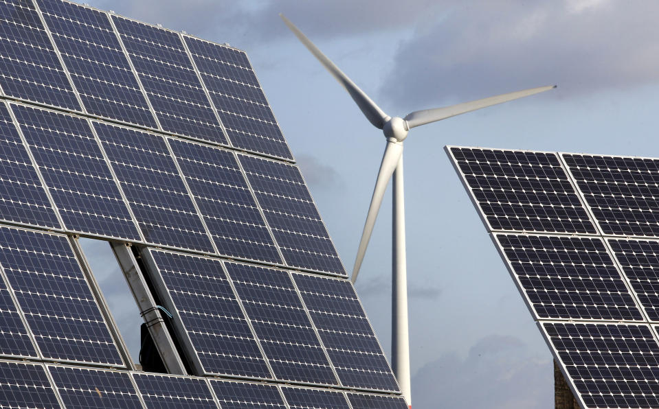 FILE - In this Nov. 30, 2011 file photo photovoltaic modules and a windmill of the wind farm are pictured at the village of Feldheim near Berlin, Germany. The crisis in Ukraine is underlining the urgency of Germany's biggest political challenge as Chancellor Angela Merkel's new government marks 100 days in office Wednesday, March 26, 2014, getting the country's mammoth transition from nuclear to renewable energy sources on track. The transition started in earnest when Merkel, after Japan's 2011 Fukushima nuclear disaster, abruptly accelerated Germany's exit from nuclear power. Since then, the "Energiewende" _ roughly, "energy turnaround" _ has created increasing headaches. (AP Photo/Michael Sohn, File)