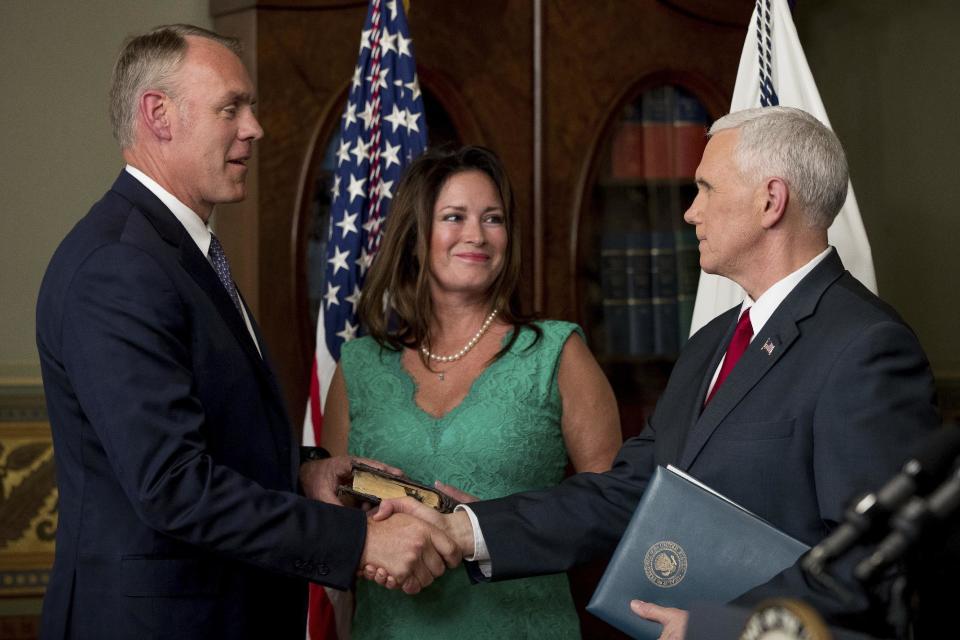 Vice President Mike Pence, right, shakes hands after administering the oath of office to Interior Secretary Ryan Zinke, left, Wednesday, March 1, 2017, in the Eisenhower Executive Office Building on the White House complex in Washington. Also pictured is Ryan Zinke's wife Lolita Hand, center. (AP Photo/Andrew Harnik)