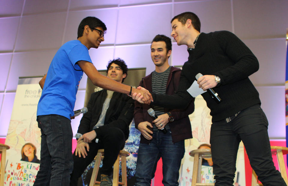 MINNEAPOLIS, MN - FEBRUARY 06: Nick Jonas of the musical trio the Jonas Brothers shakes hands with Siddartha Paari after surprising 600 students at Minneapolis Patrick Henry High School to launch 'We Day' on February 6, 2013 in Minneapolis, Minnesota. (Photo by Adam Bettcher/Getty Images for Free The Children)