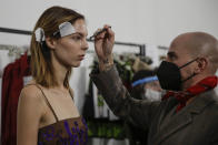 A model gets her make-up done in the backstage prior to the start of the Shi.RT women's Spring-Summer 2021 fashion show, in Milan, Italy, Sunday, Sept. 27, 2020. (AP Photo/Luca Bruno).