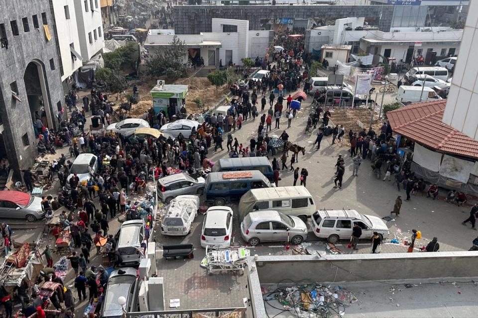 Displaced Palestinians gather in the yard of Gaza’s Al-Shifa Hospital on 10 December (AFP via Getty Images)