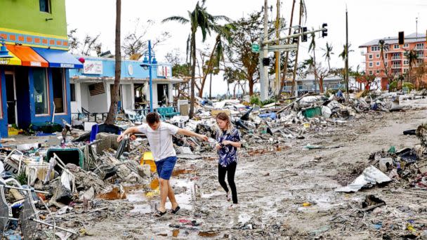 PHOTO: Jake Moses, 19, left, and Heather Jones, 18, of Fort Myers, explore a section of destroyed businesses at Fort Myers Beach, Fla., on Sep 29, 2022, following Hurricane Ian.  (Douglas R. Clifford/AP)