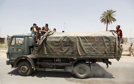 Volunteers who have joined the Iraqi army to fight against the predominantly Sunni militants, who have taken over Mosul and other Northern provinces, travel in an army truck, in Baghdad, June 12, 2014. REUTERS/Ahmed Saad
