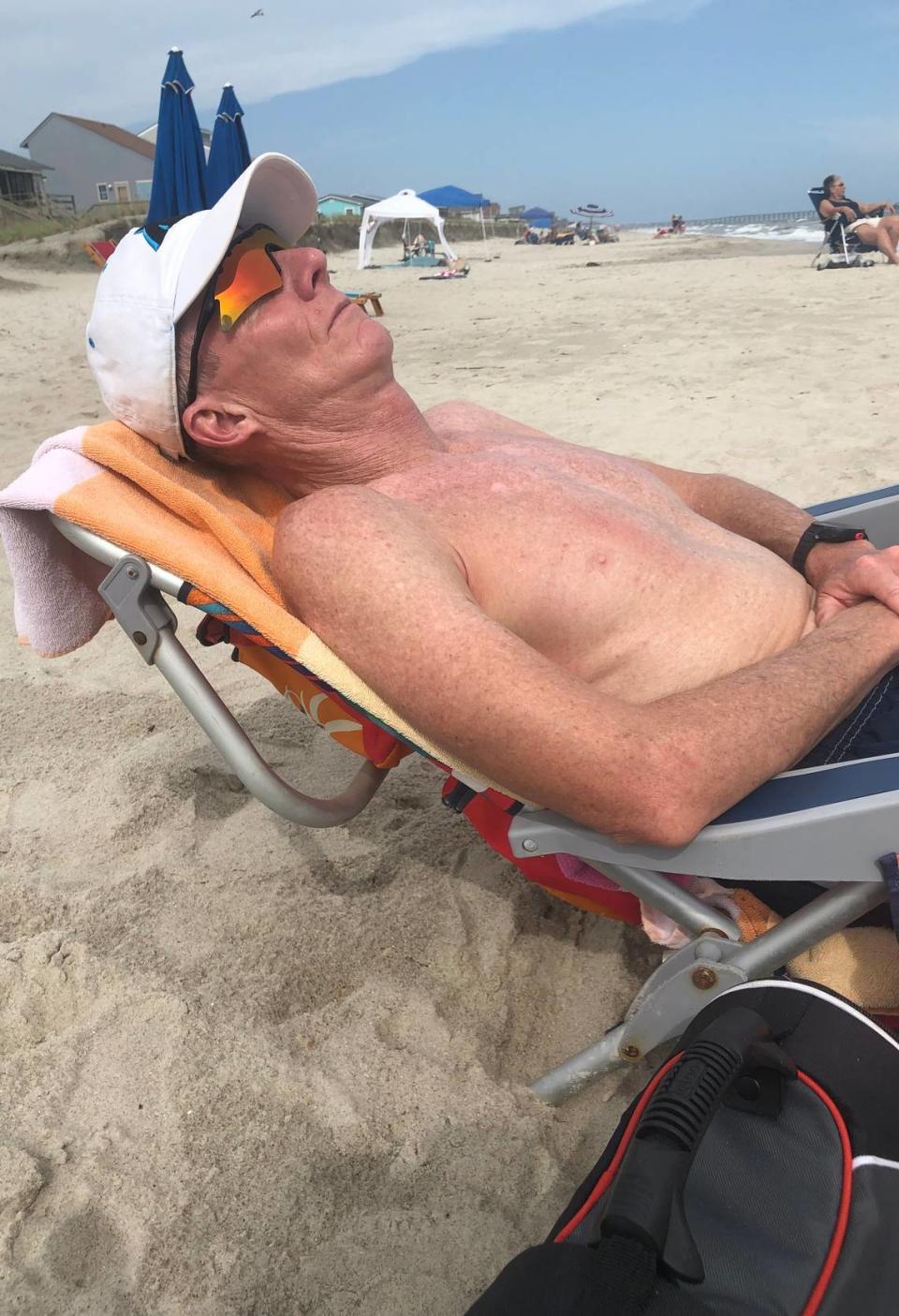 John Diggs naps on the Oak Island beach shortly before he was struck by the wave that broke his neck on July 11.