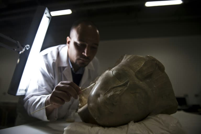 Archaeologist Basem Gehad cleans a pharaoh's head at the Grand Egyptian Museum, still under construction, near the Giza pyramids in Cairo on June 4, 2015