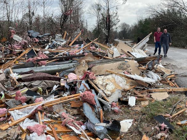 PHOTO: People walk through an area of destroyed structures in Flatwood, Ala., Nov. 30, 2022.  (Butch Dill/AP)