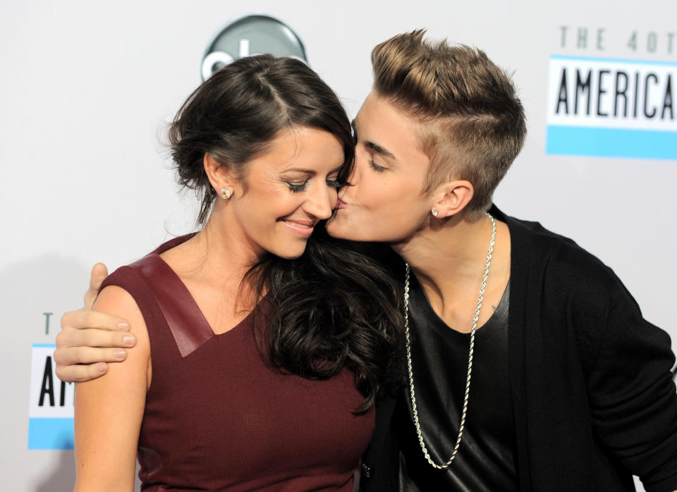 FILE - In this Nov. 18, 2012 file photo, Justin Bieber, right, kisses his mother Pattie Mallette at the 40th Anniversary American Music Awards in Los Angeles. Mallette, has left out some of the rougher details of her early life for a new teen edition of her memoir, "Nowhere But Up." Out Tuesday, July 2, 2013, from the inspirational publisher Revell, the book includes advice, statistics and hotline numbers for young people on depression, pregnancy, bullying and unwanted sexual advances. (Photo by Jordan Strauss/Invision/AP, File)