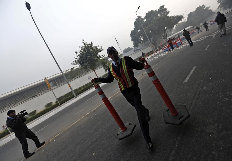 A U.S. embassy security guard removes the barriers from outside the U.S. embassy in New Delhi