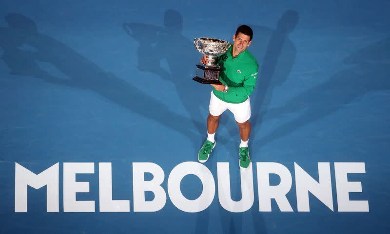 El serbio Novak Djokovic celebra con el trofeo después de ganar su partido contra el austríaco Dominic Thiem en el Abierto de Australia, en Melbourne.