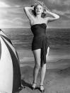 <p>Lucille Ball poses for a glamour shot next to a giant beach umbrella in 1943.</p>