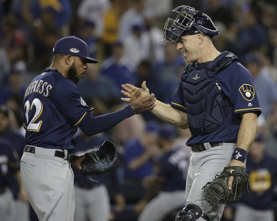 Milwaukee Brewers' Jeremy Jeffress and catcher Erik Kratz celebrate after Game 3 of the National League Championship Series baseball game against the Los Angeles Dodgers Monday, Oct. 15, 2018, in Los Angeles. The Brewers won 4-0 to take a 2-1 lead in the series. (AP Photo/Jae Hong)