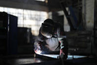 Un operario suelda parte de un búnker en una planta de Metinvest en Krivói Rog, Ucrania, el 2 de marzo de 2023. La factoría, que forma parte del consorcio de siderurgia y minería de Metinvest, envía refugios de metal al frente. (AP Foto/Thibault Camus)