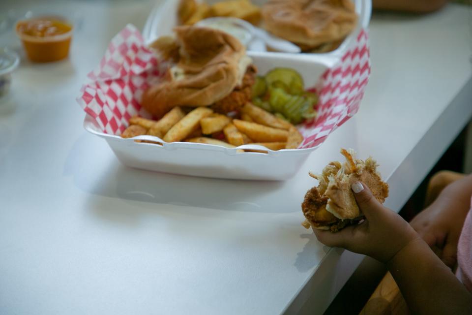 The Angeles family enjoys sliders at Hot Chicken Run, located at 6917 S. Staples St. Saturday, Aug. 26, 2023.