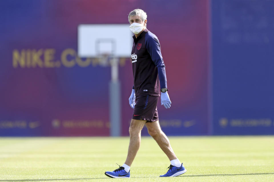 In this photo provided by FC Barcelona, Barcelona's coach Quique Setien watches his players doing a training session in Barcelona, Spain on Friday May 8, 2020. Soccer players in Spanish player returned to train for the first time since the country entered a lockdown nearly two months ago because of the coronavirus pandemic. (Miguel Ruiz/FC Barcelona via AP)