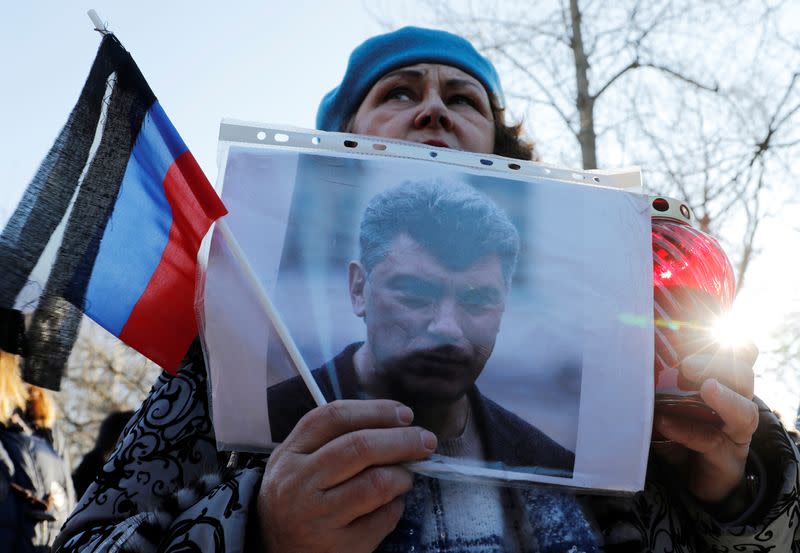 A woman holds a photo of Russian opposition politician Boris Nemtsov during a rally marking the 5th anniversary of his assassination, in Saint Petersburg