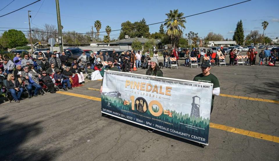 Parade participants carry Pinedale’s centennial banner to start the parade for the community’s centennial celebration outside the Pinedale Community Center on Saturday, March 25, 2023. The community in north Fresno is celebrating the 100th anniversary of its establishment.