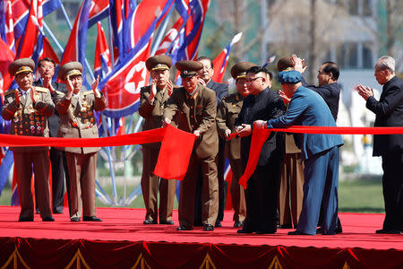 North Korean leader Kim Jong Un cuts the ribbon during an opening ceremony of a newly constructed residential complex in Ryomyong street in Pyongyang, North Korea April 13, 2017. REUTERS/Damir Sagolj