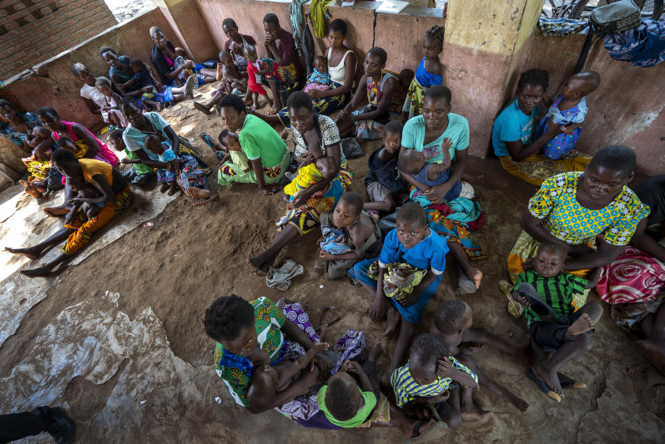 In this photo taken Wednesday, Dec. 11, 2019, residents of the Malawi village of Tomali wait to have their young children become test subjects for the world's first vaccine against malaria. Babies in three African nations are getting the first and only vaccine for malaria in a pilot program. World health officials want to see how well the vaccine works in Malawi, Ghana and Kenya before recommending its wider use. (AP Photo/Jerome Delay)