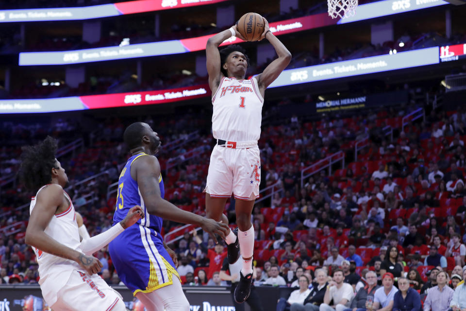 Houston Rockets forward Amen Thompson (1) dunks over Golden State Warriors forward Draymond Green, center, and Rockets guard Jalen Green, left, during the first half of an NBA basketball game Thursday, April 4, 2024, in Houston. (AP Photo/Michael Wyke)