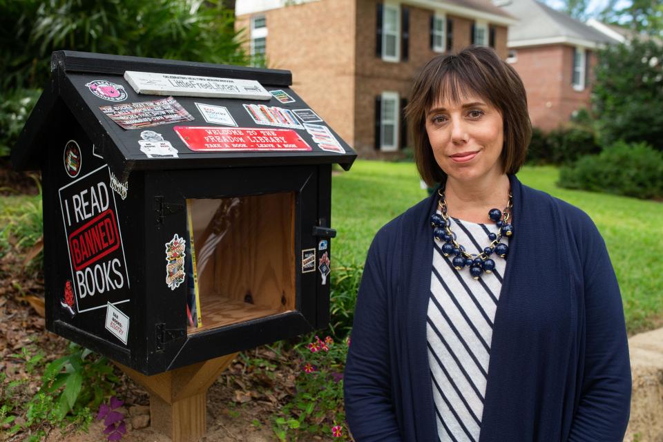 Heather Encinosa stocks her “little free library,” located in Betton Hills, with banned books, giving the public access to reading books that have been banned in Florida schools.