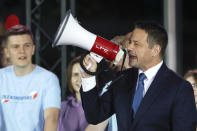 Presidential candidate Rafal Trzaskowski uses a megaphone while addressing supporters at the end of the election day in Warsaw, Poland, Sunday, July 12, 2020. Voting ended in Poland's razor-blade-close presidential election runoff between the conservative incumbent Andrzej Duda and liberal, pro-European Union Warsaw Mayor Rafal Trzaskowski with exit polls showing the election is too close to call. (AP Photo/Petr David Josek)